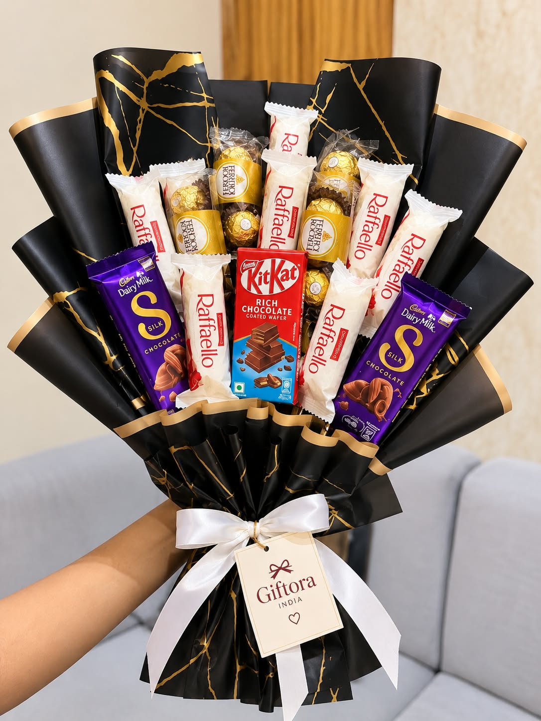 Giftora India chocolate bouquet with black and gold wrapping and a white ribbon